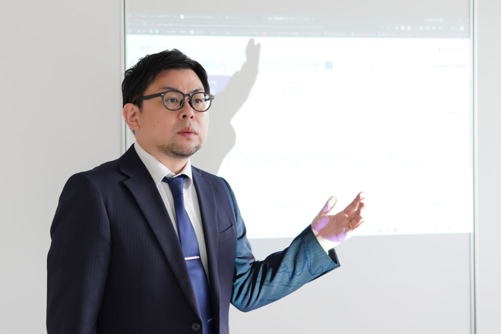 スクリーンの分析画面を示しながら説明する代表