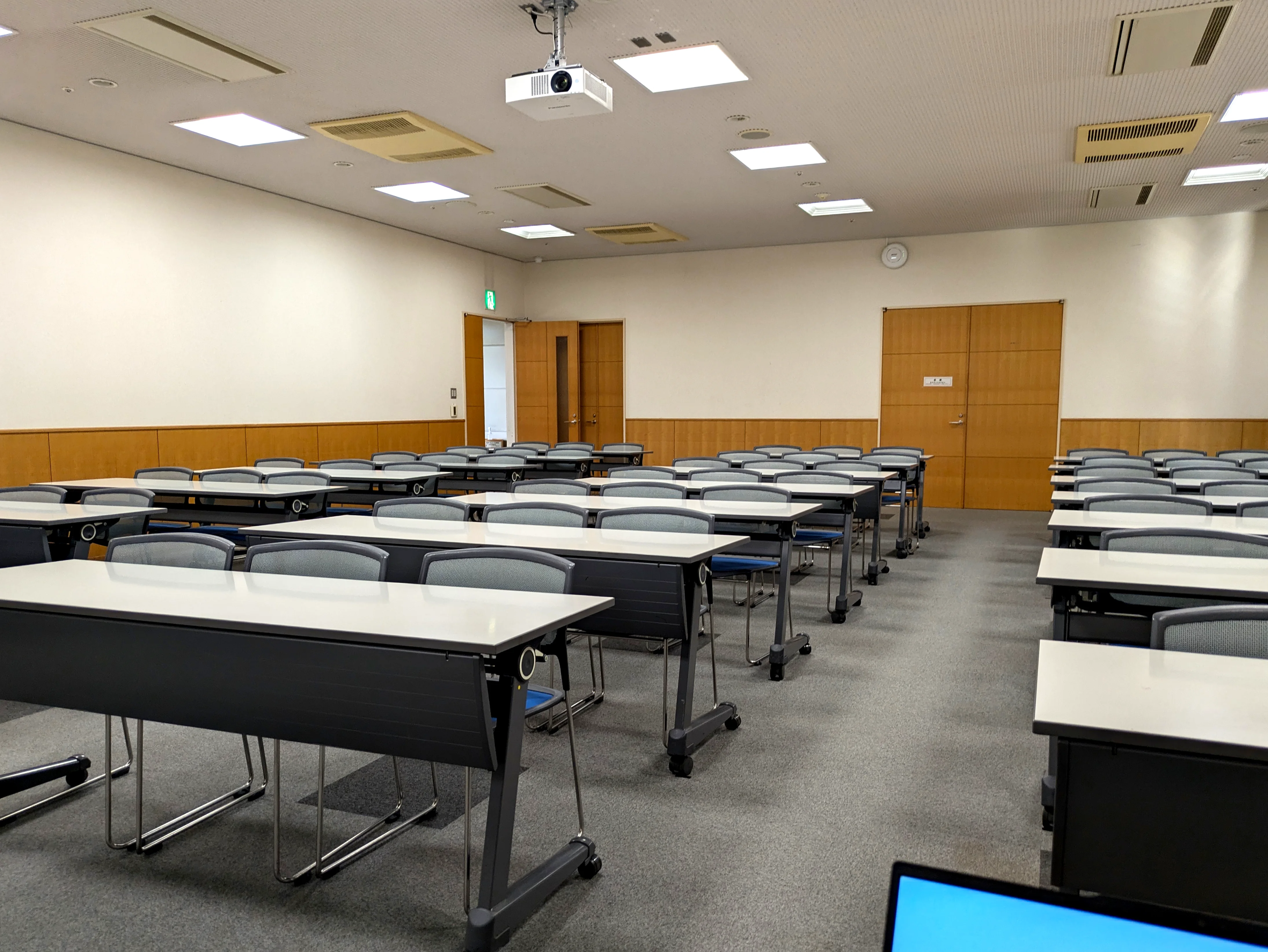 明るい会場に並ぶセミナー用のテーブルと椅子